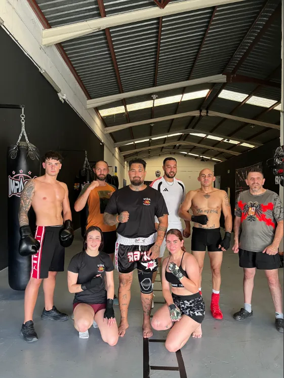 Equipo de K1 del club junto a los sacos de entrenamiento
